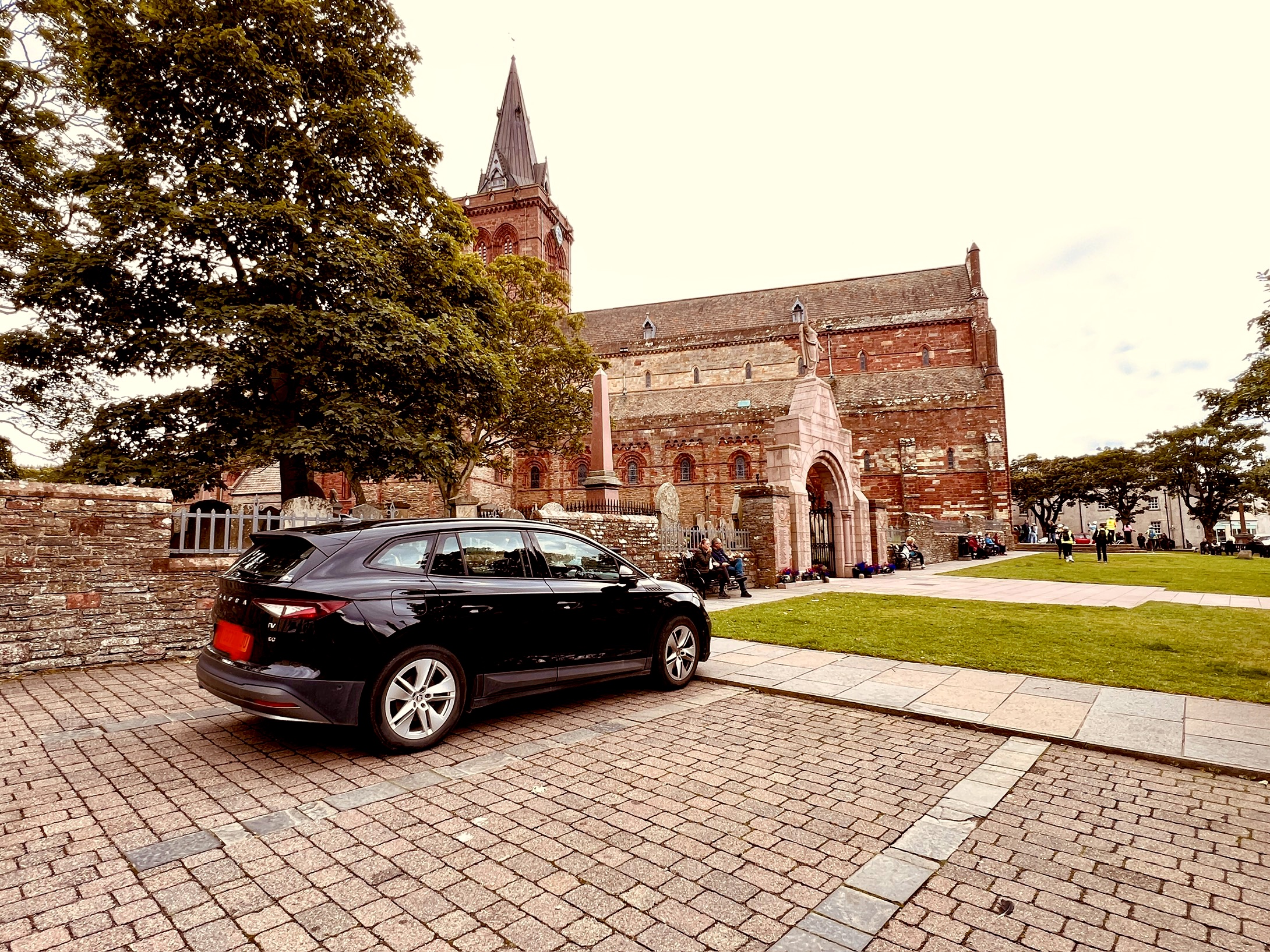 Urlaubs-Schnappschuss: Ein Enyaq geniesst die Aussicht auf eine Kathedrale in Kirkwall (Schottische Insel Orkney)